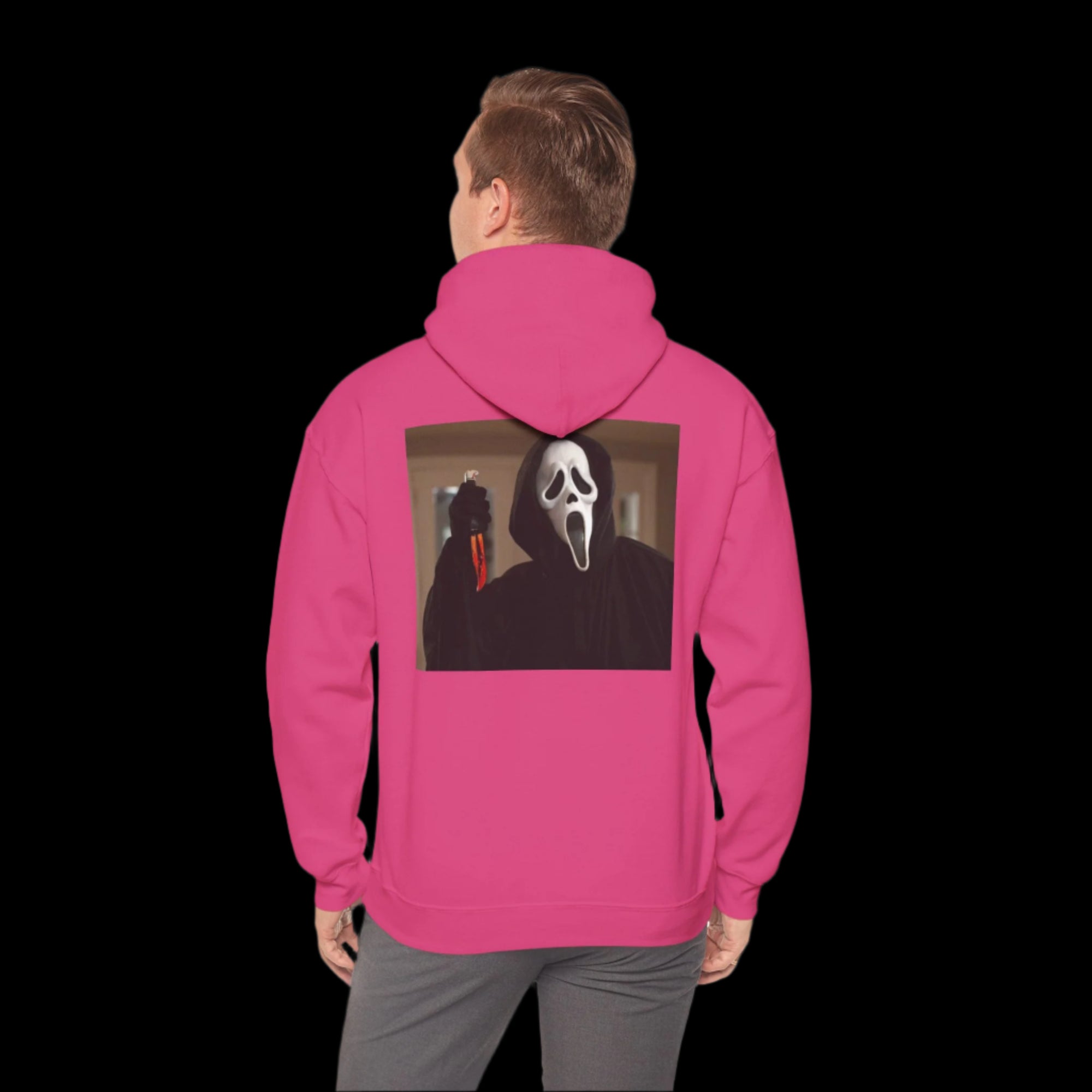 Person wearing a pink hoodie with ghostface design on the back, standing against a white background